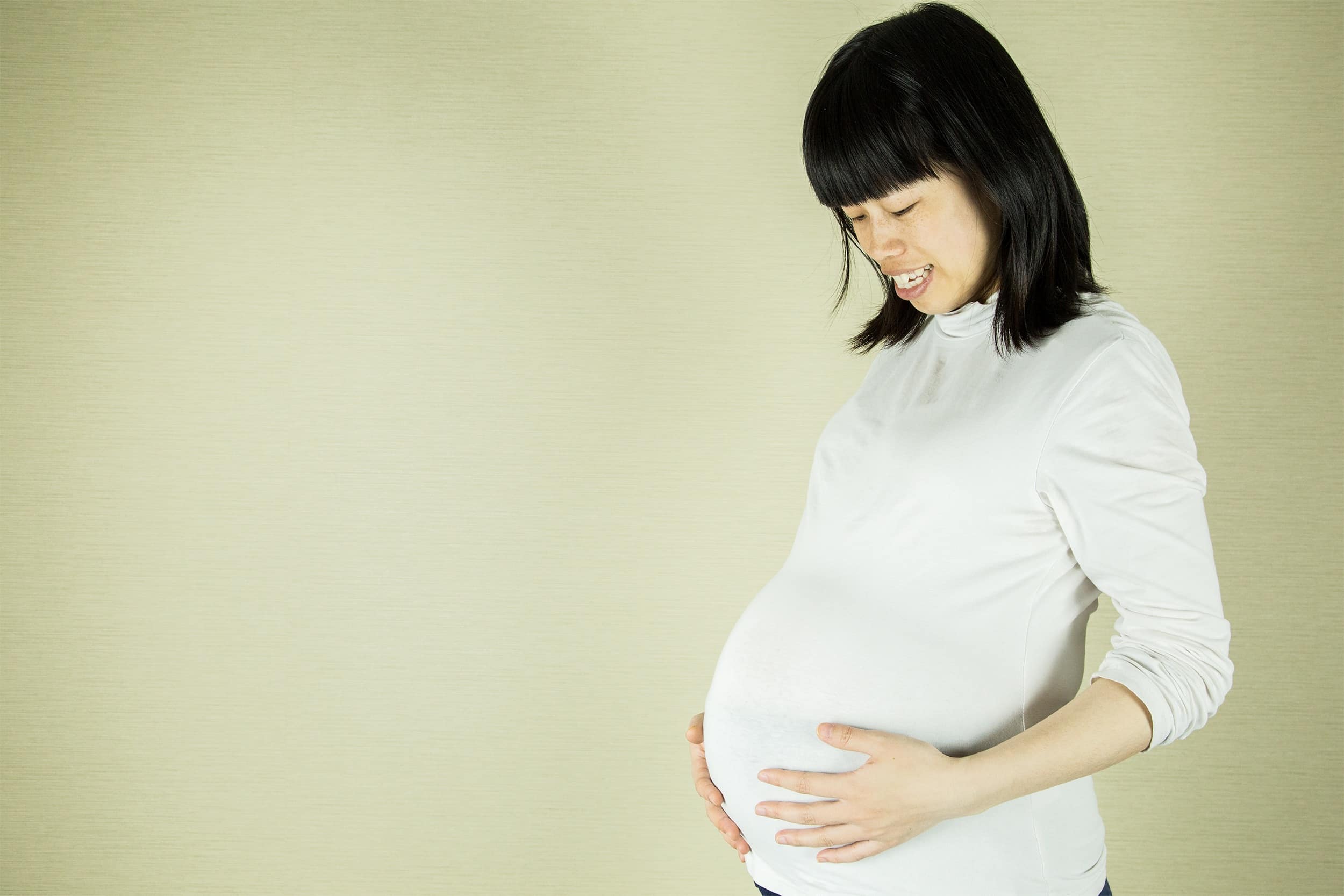 Happy pregnant woman who has overcome childbirth anxiety through mental health counseling
