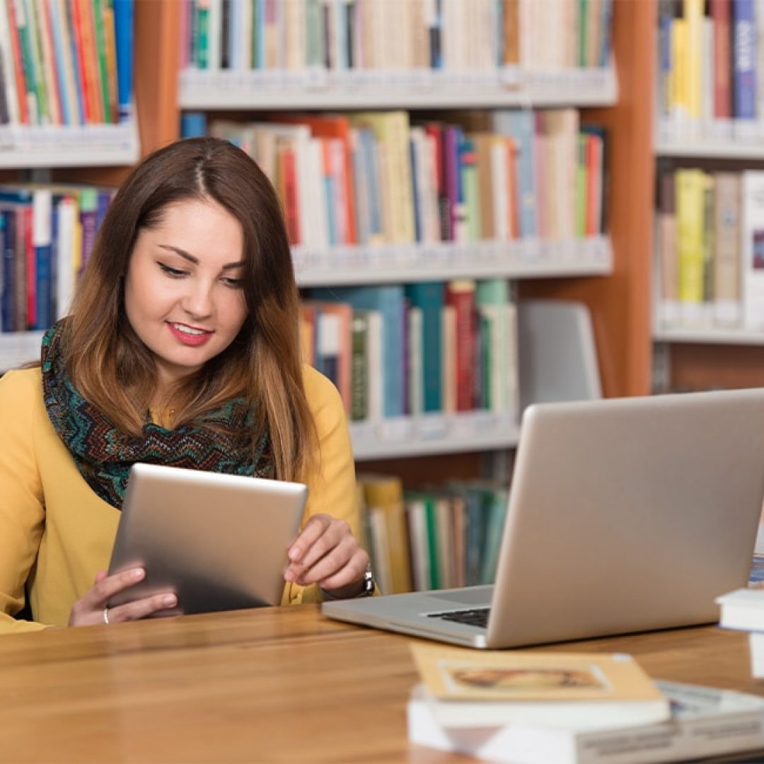Beautiful Female Student With Laptop And Books Working In A High School