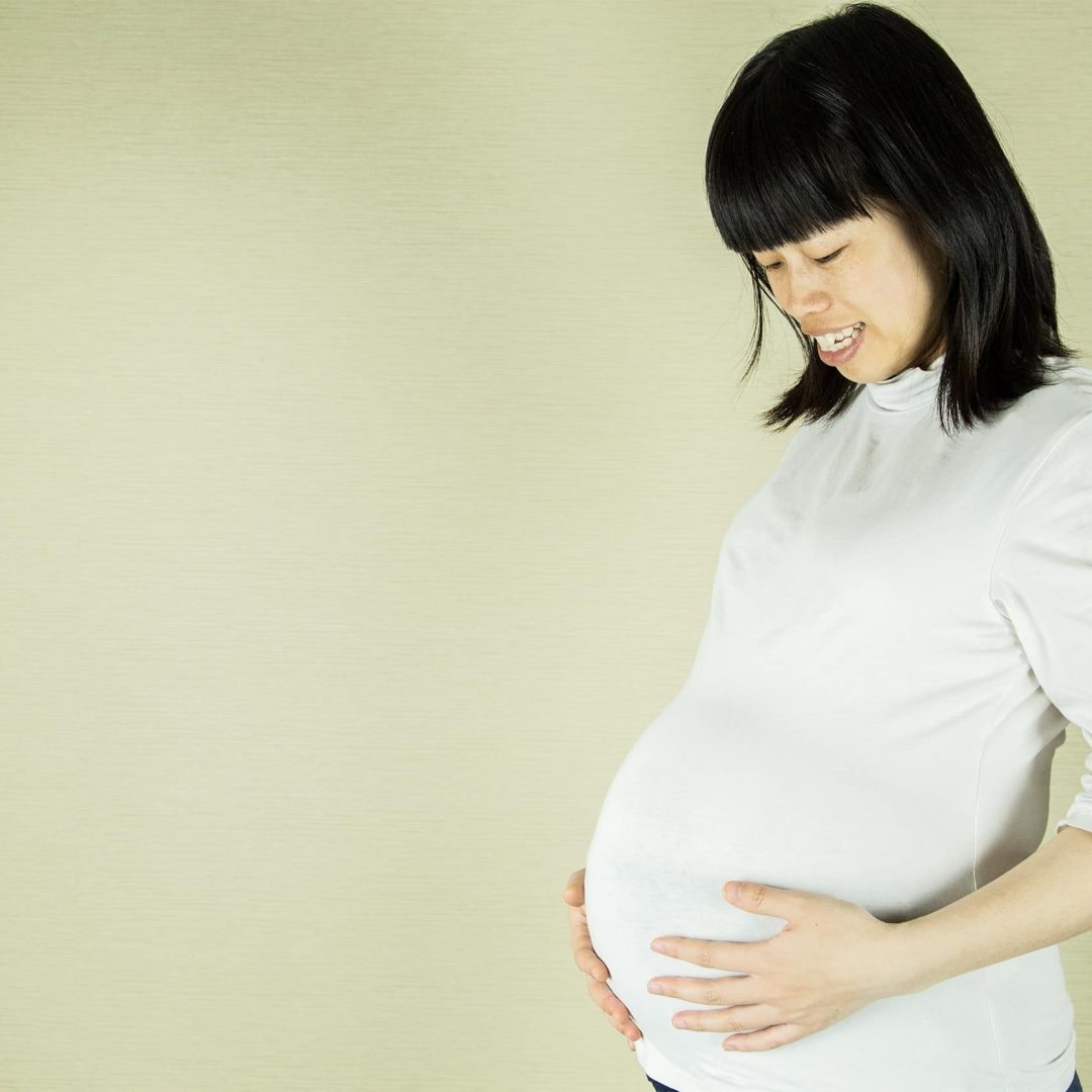 Happy pregnant woman who has overcome childbirth anxiety through mental health counseling